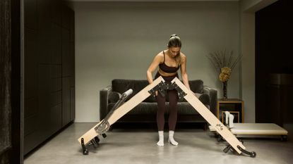 A woman folding up the FOLD Reformer