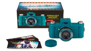 Lomography Sprocket Rocket 35mm Panoramic Camera in Peacock colorway, next to box and box contents