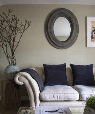 A living room mirror idea with wooden frame and neutral color scheme