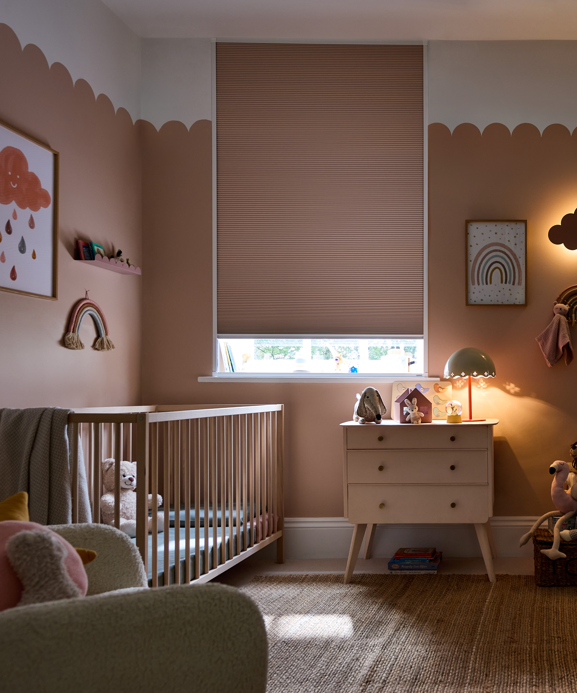 nursery painted in peach and white with peach blind closed at window