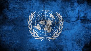 The UN flag image on a blue stone wall