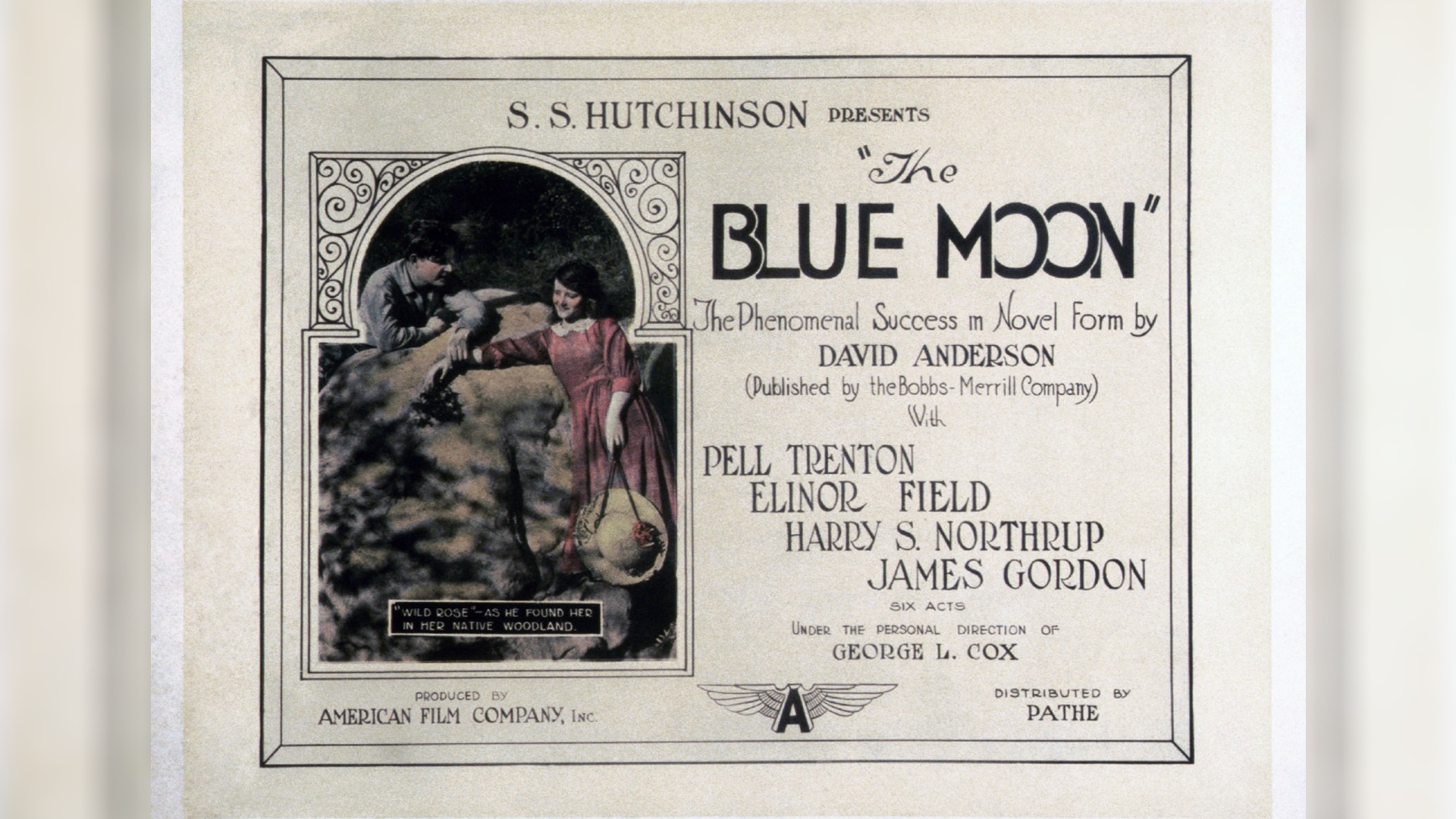 a vintage advertisement for a film showing a man and a woman smiling at one another on opposite sides of a garden wall under the title "the blue moon"