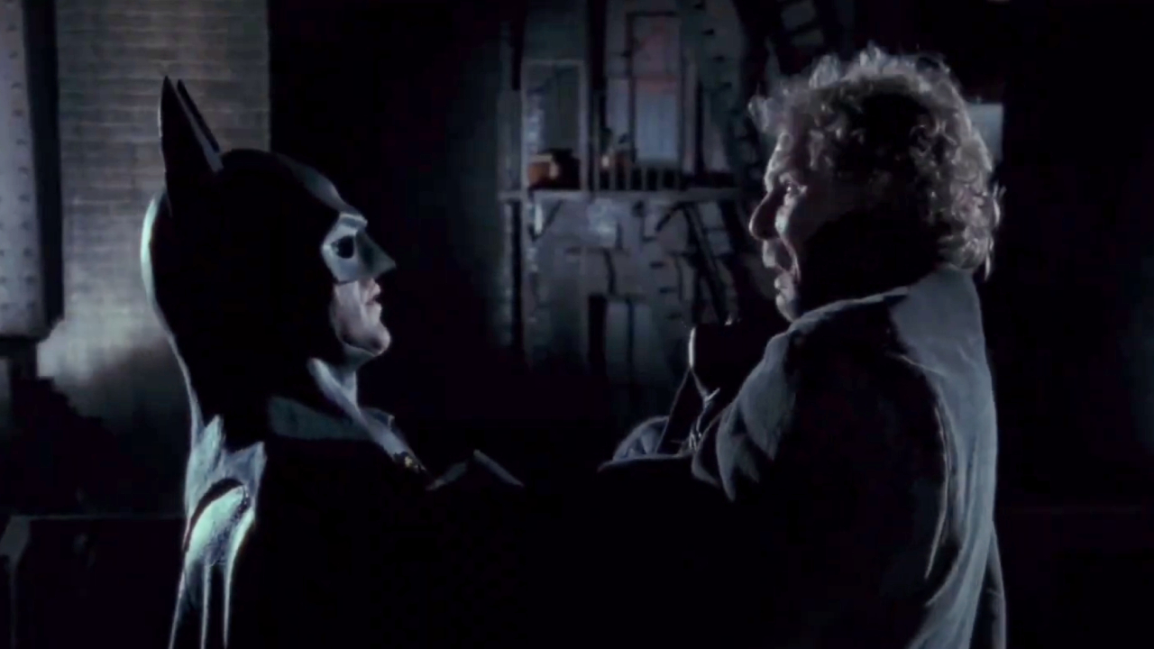 Michael Keaton as Batman strong-arming a thug in Batman