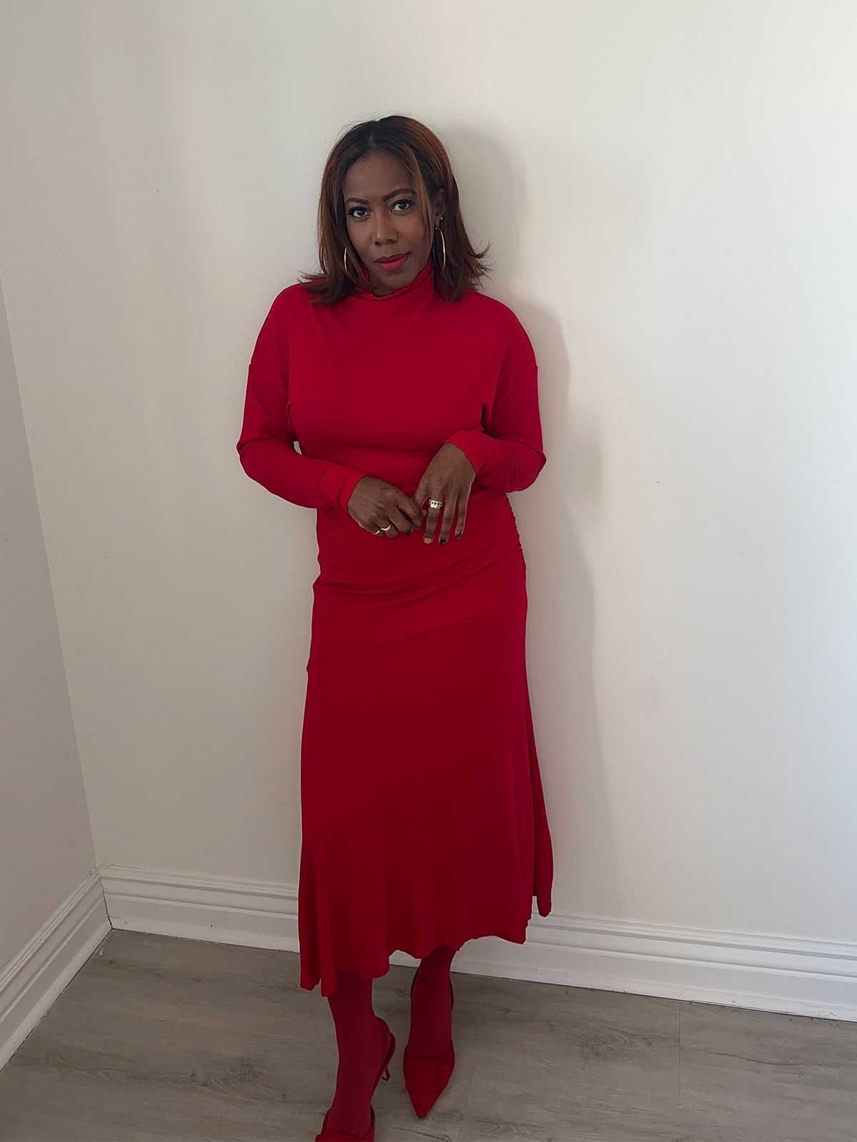 Tiffany Reid wearing monochromatic red outfit from her fashion editor guide to holiday hosting.