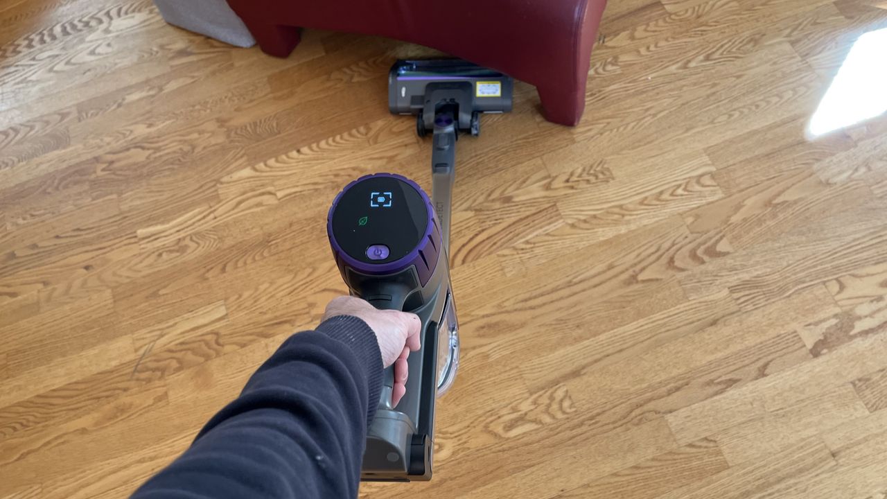 Shark Cordless PowerDetect Clean and Empty System vacuuming wooden floor, folded using the telescopic tube