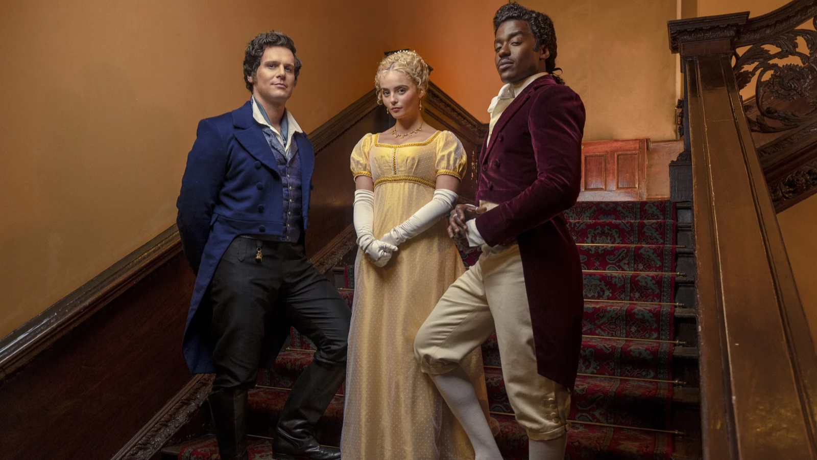 Actors Jonathan Groff, Millie Gibson, and Ncuti Gatwa wear regal attire and stand on a staircase in Doctor Who season 14