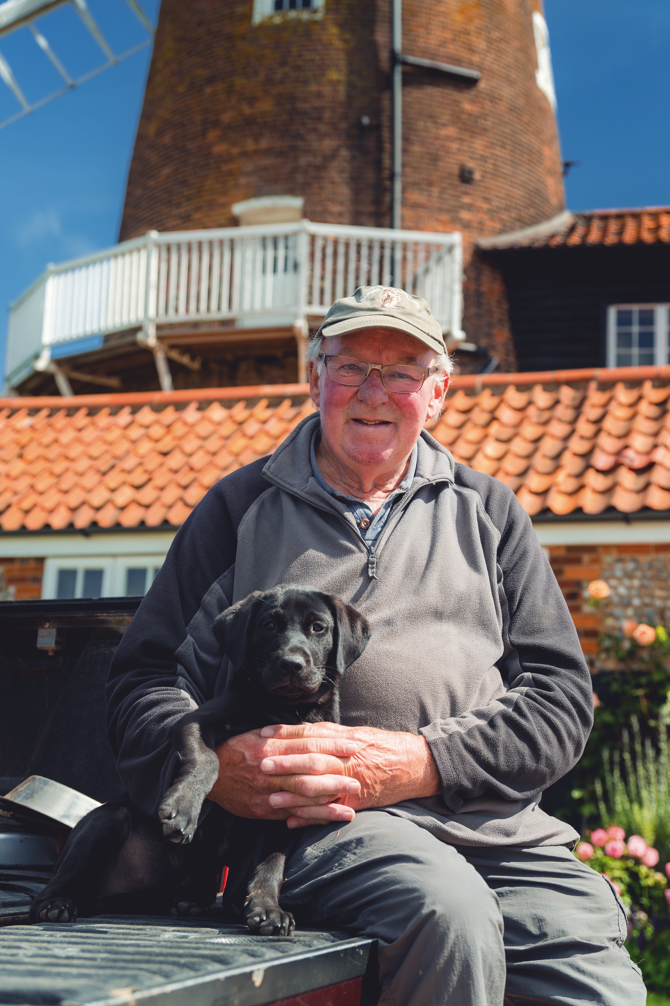 Bernard Bishop with his labrador puppy Bramble in front of Cley Windmill