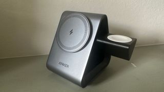 Anker 737 MagGo Charger (3-in-1 Station) on a gray surface, the Apple Watch stand pulled out