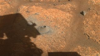 This image taken by one the hazard cameras aboard NASA’s Perseverance rover on Aug. 6, 2021, shows the hole drilled in what the rover science team calls a “paver rock” in preparation for the mission’s first attempt to collect a sample from Mars.