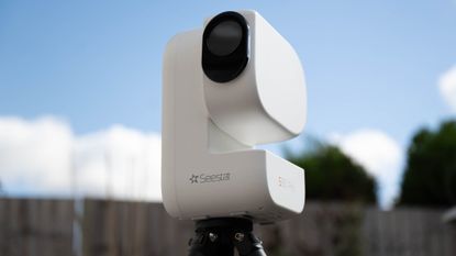 ZWO Seestar S50 Pro on a tripod against a green shed
