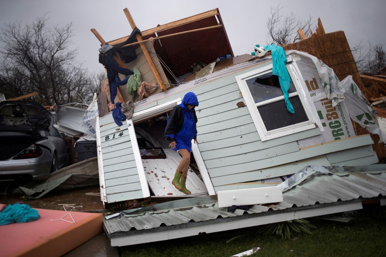 Barbara Koster stands on her front door as she surveys her property which was left devastated by Hurricane Harvey in Rockport, Texas.