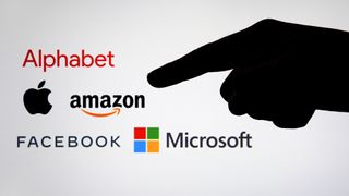 The silhouette of a finger pointing at the logos of big tech companies
