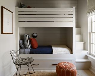 calming bedroom with bunkbeds, black metal chair and navy blue bedding