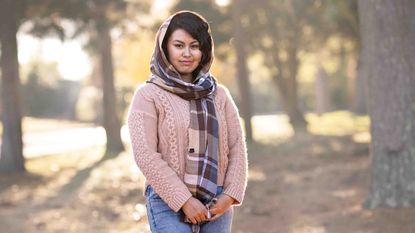 Photo of a woman with a head scarf standing outdoors