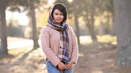 Photo of a woman with a head scarf standing outdoors