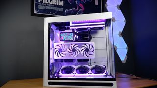 A finished white gaming PC on a table with Nanoleaf lighting panels behind it and RGB enabled.