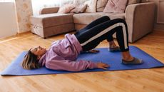 Woman doing glute bridge at home on a yoga mat