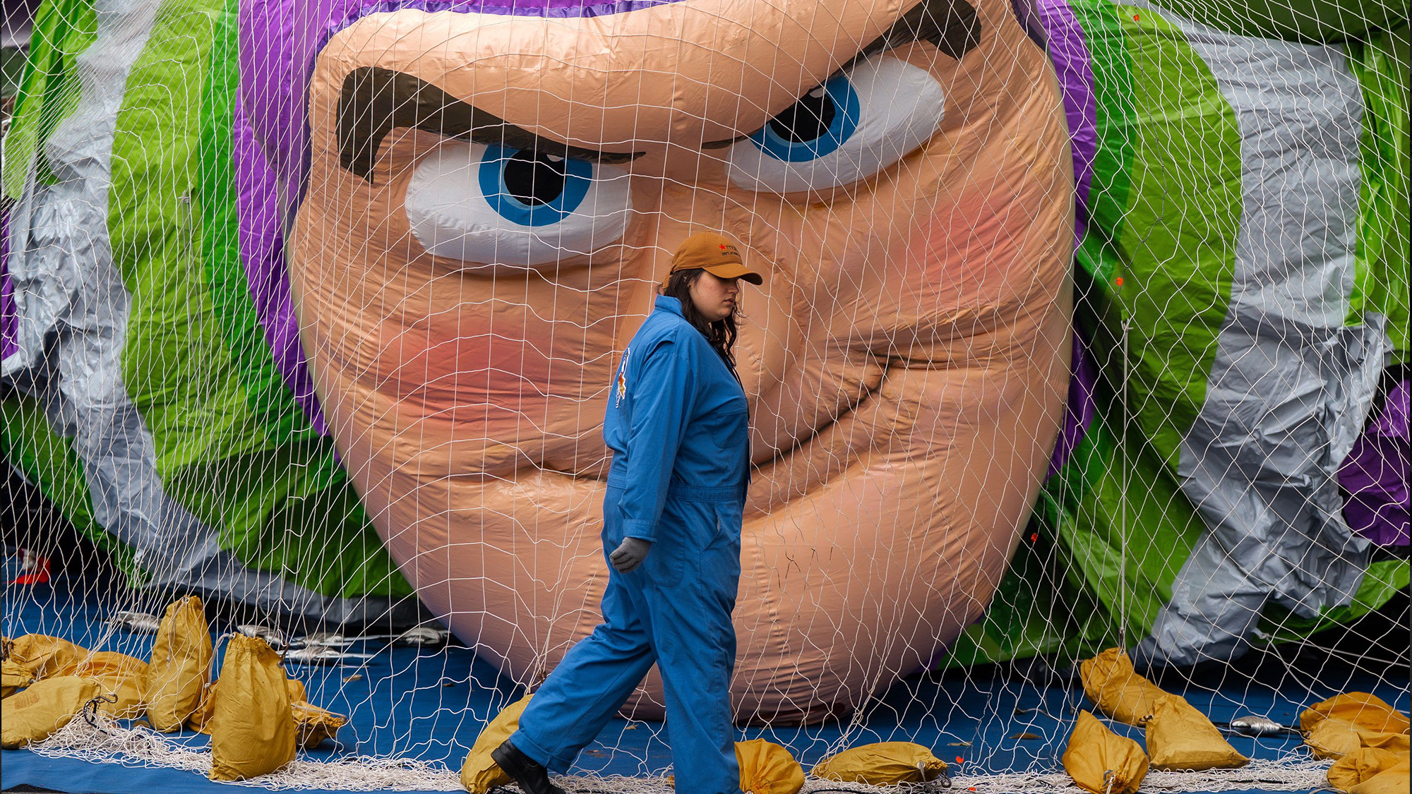 A balloon handler walks past a partially inflated Buzz Lightyear balloon, in preparation for the Thanksgiving Day Parade in New York, USA