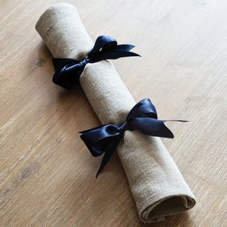 Off white napkin cracker with blue ribbon