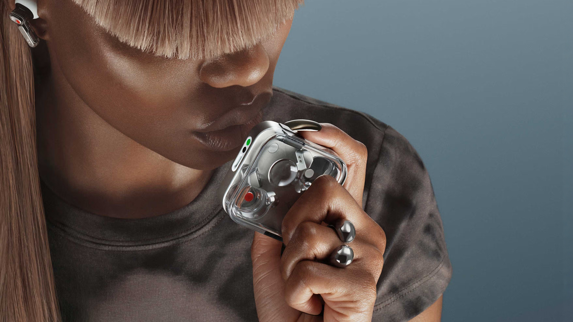 Nothing Ear (3) held by woman against a blue background