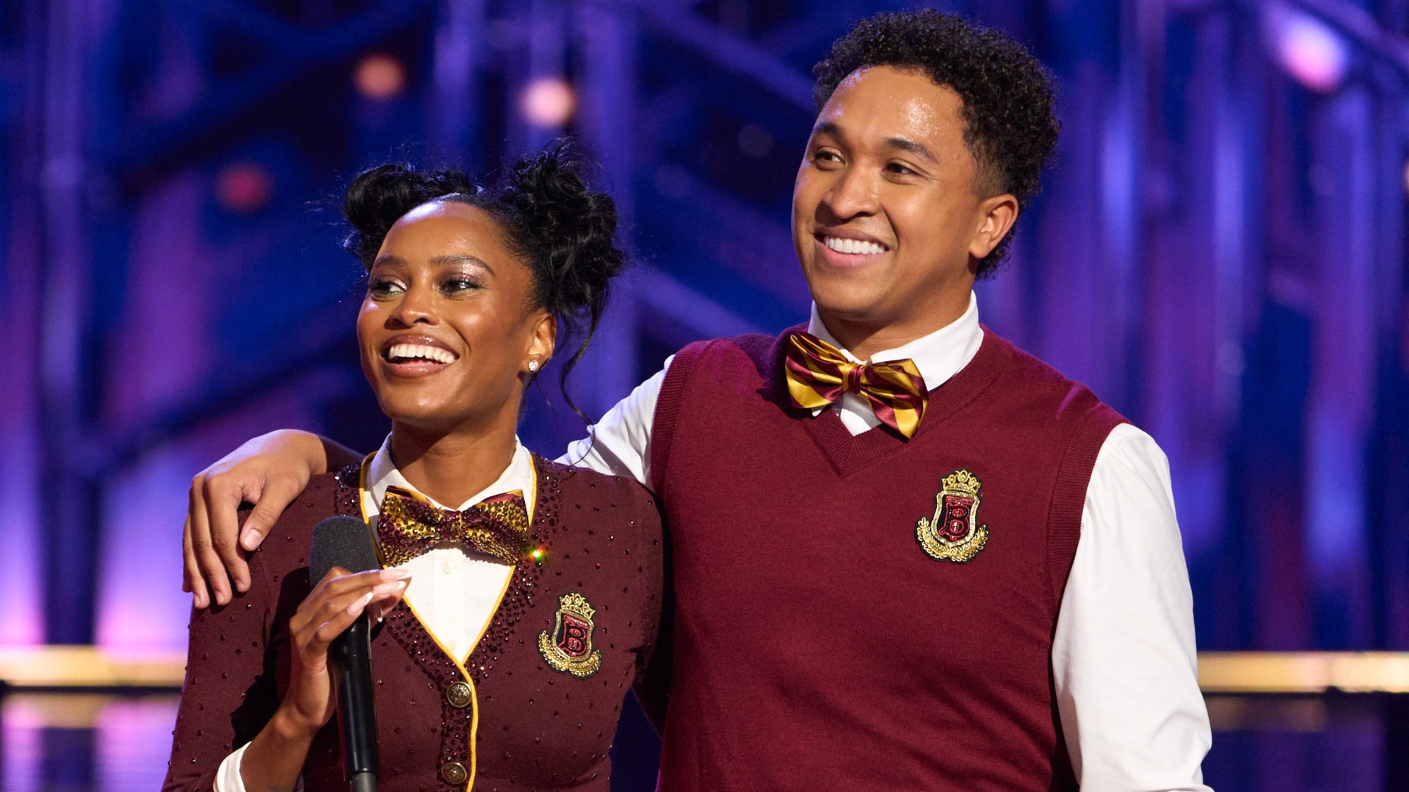 Ciara Miller and Brandon Armstrong wearing red costumes that have yellow accents on Dancing with the Stars.