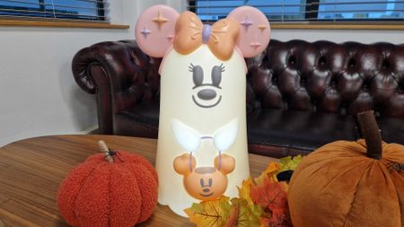 Disney Halloween ghost with Minnie ears, lit up amongst autumnal decorations
