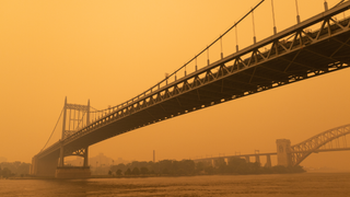The Triborough Bridge along the East River in New York City with massive air pollution in the sky from wildfires.