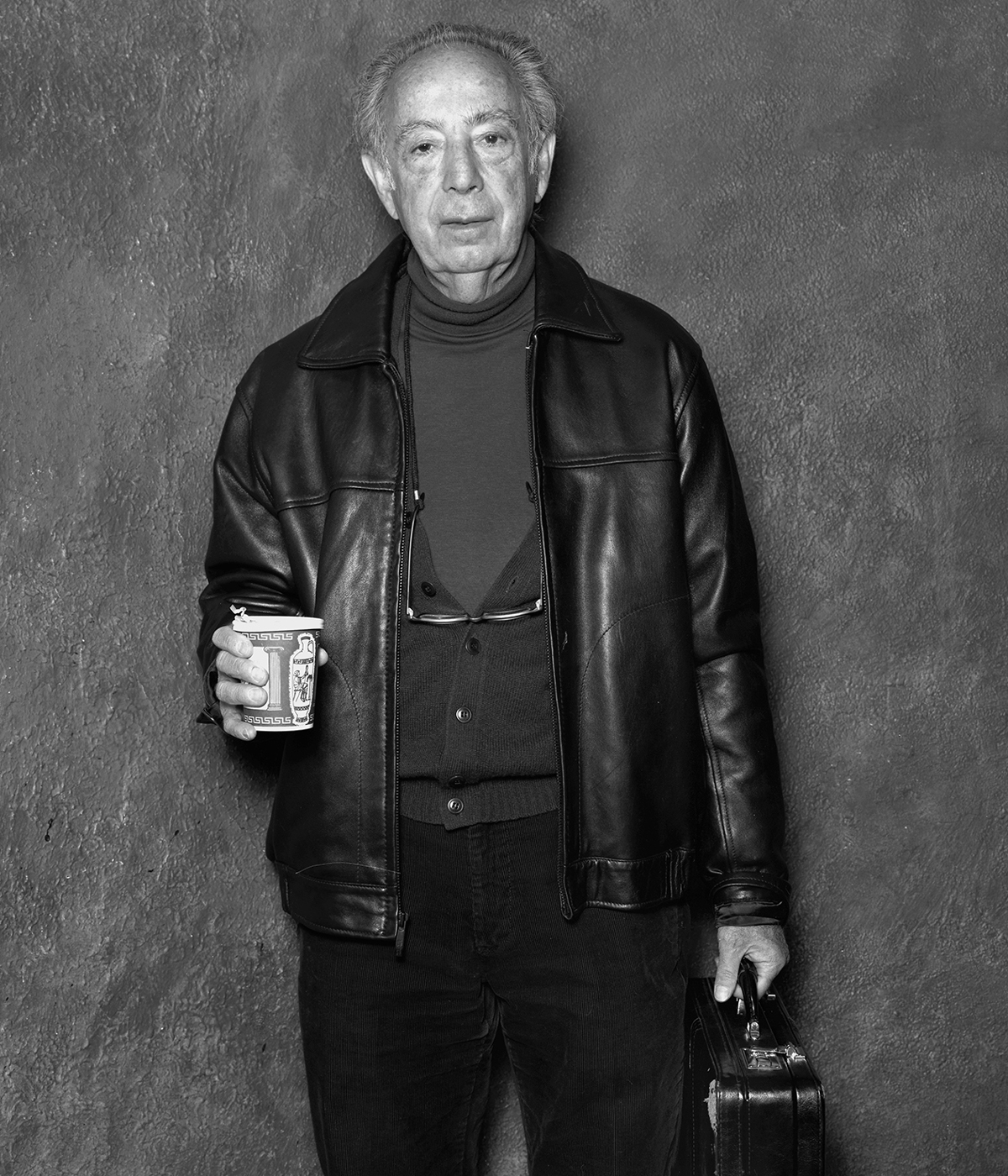 black and white portrait of Stanley Bard holding coffee and briefcase