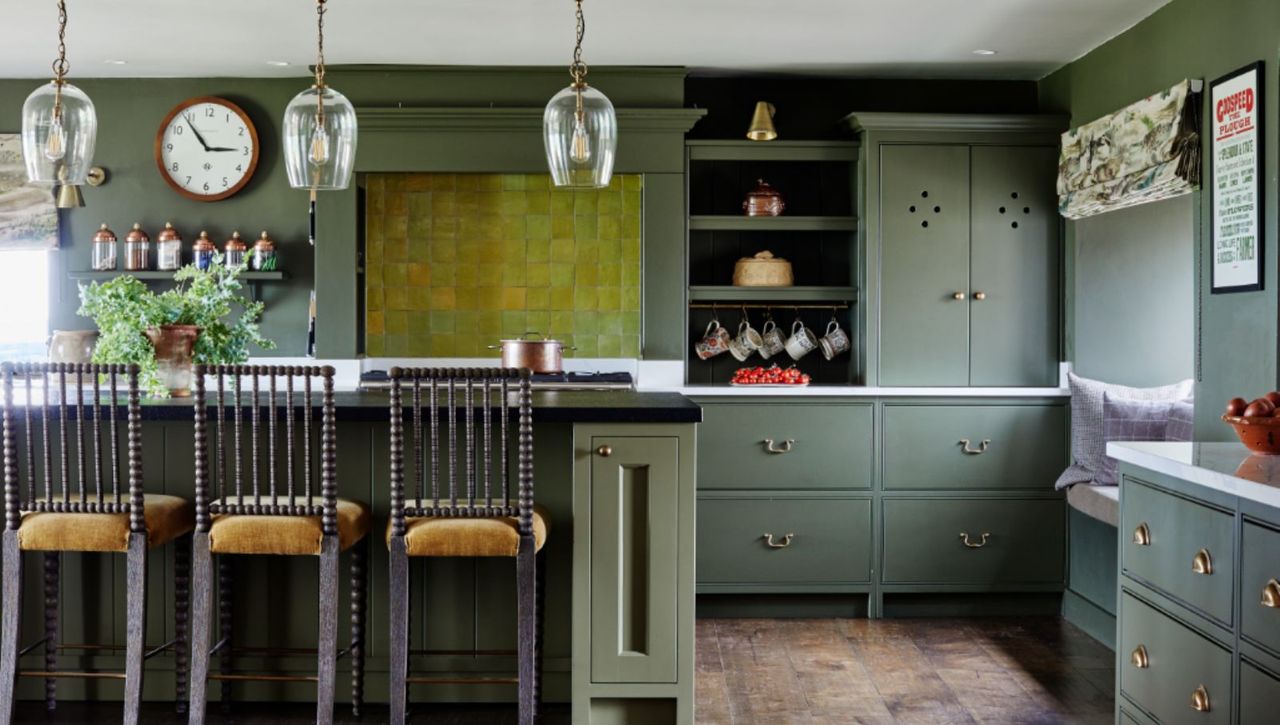 Green kitchen with kitchen island and wooden bar stools