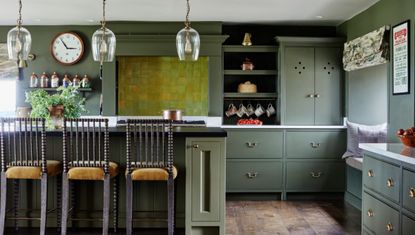 Green kitchen with kitchen island and wooden bar stools