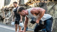 Chris Hemsworth and Luke Zocchi working out outdoors using dumbbells and kettlebells