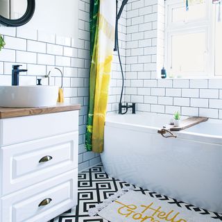 small white bathroom with metro tiles and yellow shower curtain