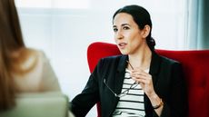 A businesswoman looks serious while she talks to another woman. 