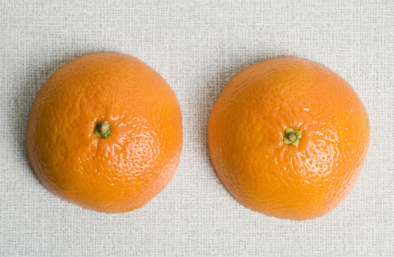 Two halves on an orange on a table, nipple orgasms