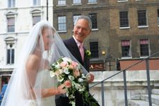 The father of the bride walks his daughter up the church stairs to the wedding.