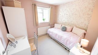 A pink bedroom with a smaller day bed