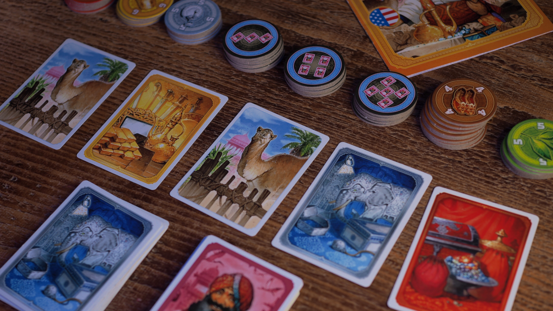 Jaipur box, cards, and tokens laid out on a wooden table