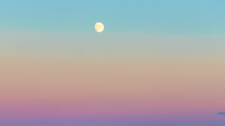 a full moon on a sunset