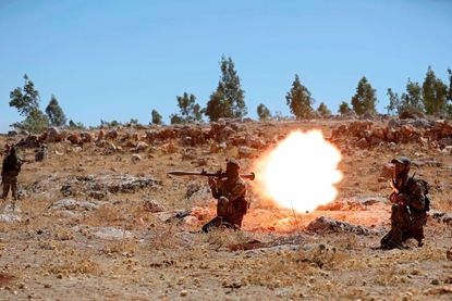 A Syrian fighter fires a rocket-propelled grenade as he attends a mock battle in anticipation of an attack by the regime on Idlib province.
