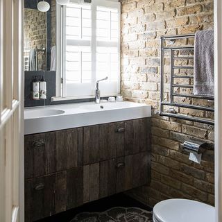 cloakroom with brick wall and white basin