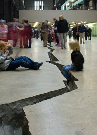 A close up of visitors inspecting the floor crack.