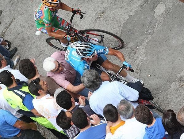 Riders struggle to keep going on the final climb, and get help from tifosi.