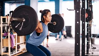 A woman squats weights