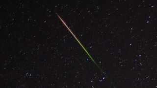 a streak of light crosses through the night sky