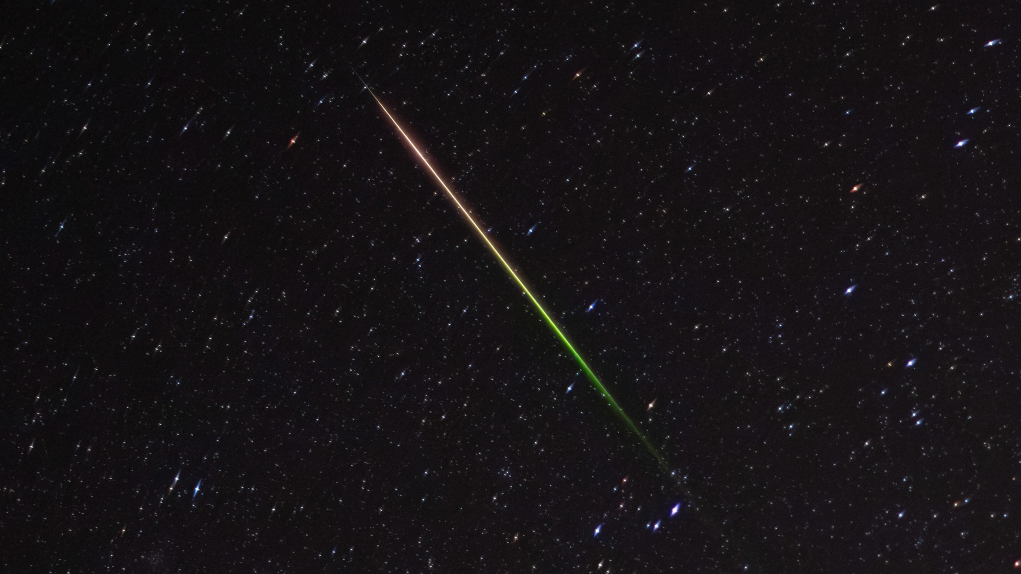 a streak of light crosses through the night sky