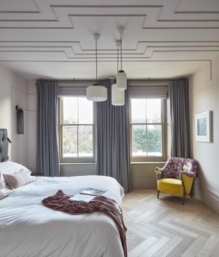 bedroom with wooden floors, two sash windows and beaded ceiling