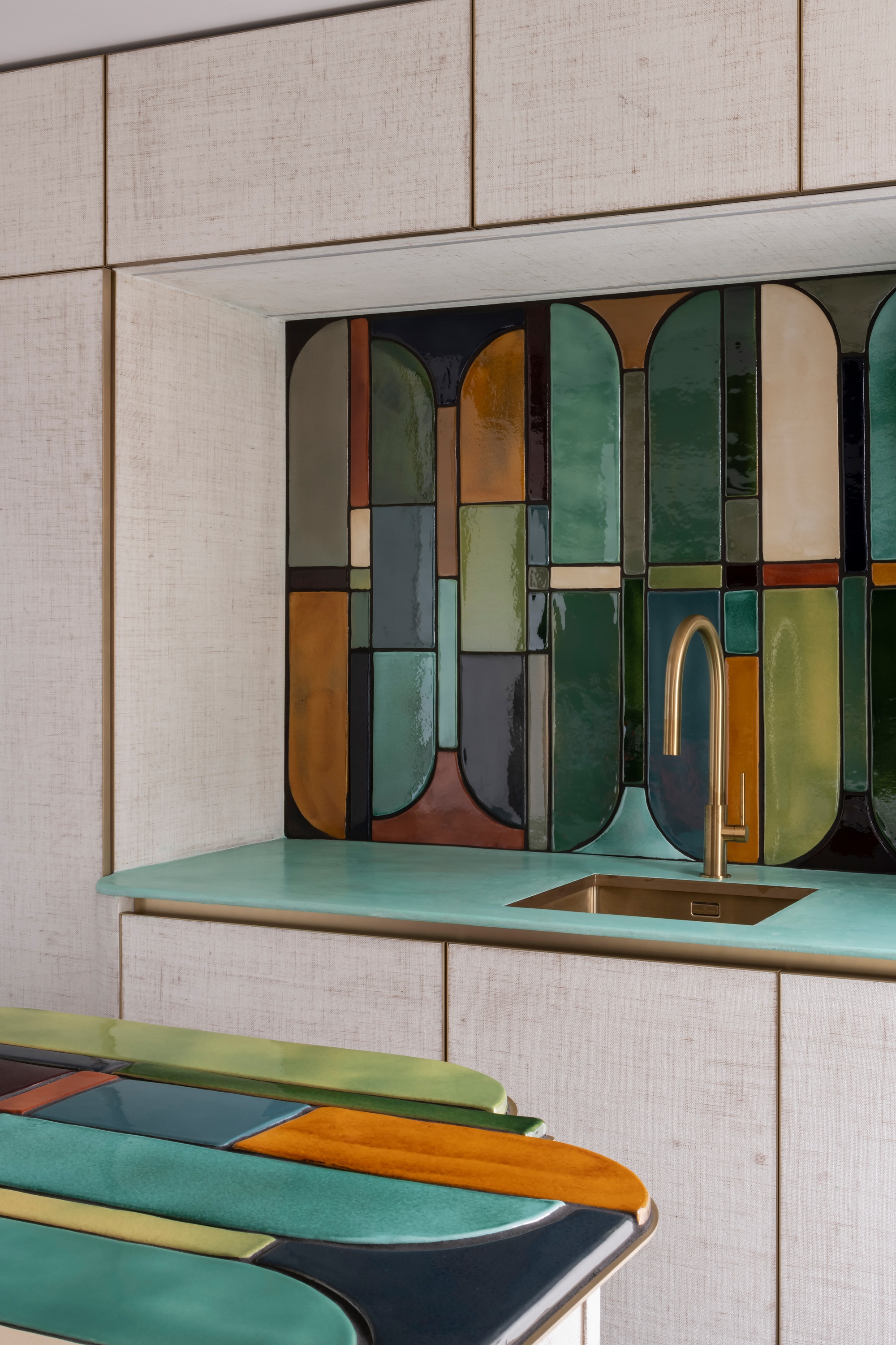 a kitchen with a colorful ceramic art deco inspired backsplash and kitchen island countertop