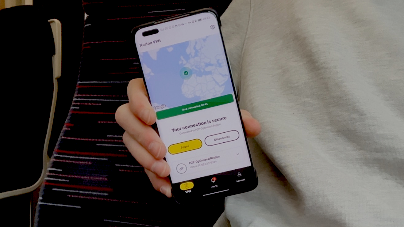 Hand holding an Android phone with the Norton VPN app running on it.