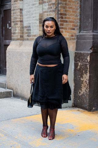 A model at New York Fashion Week in a crop top and black skirt