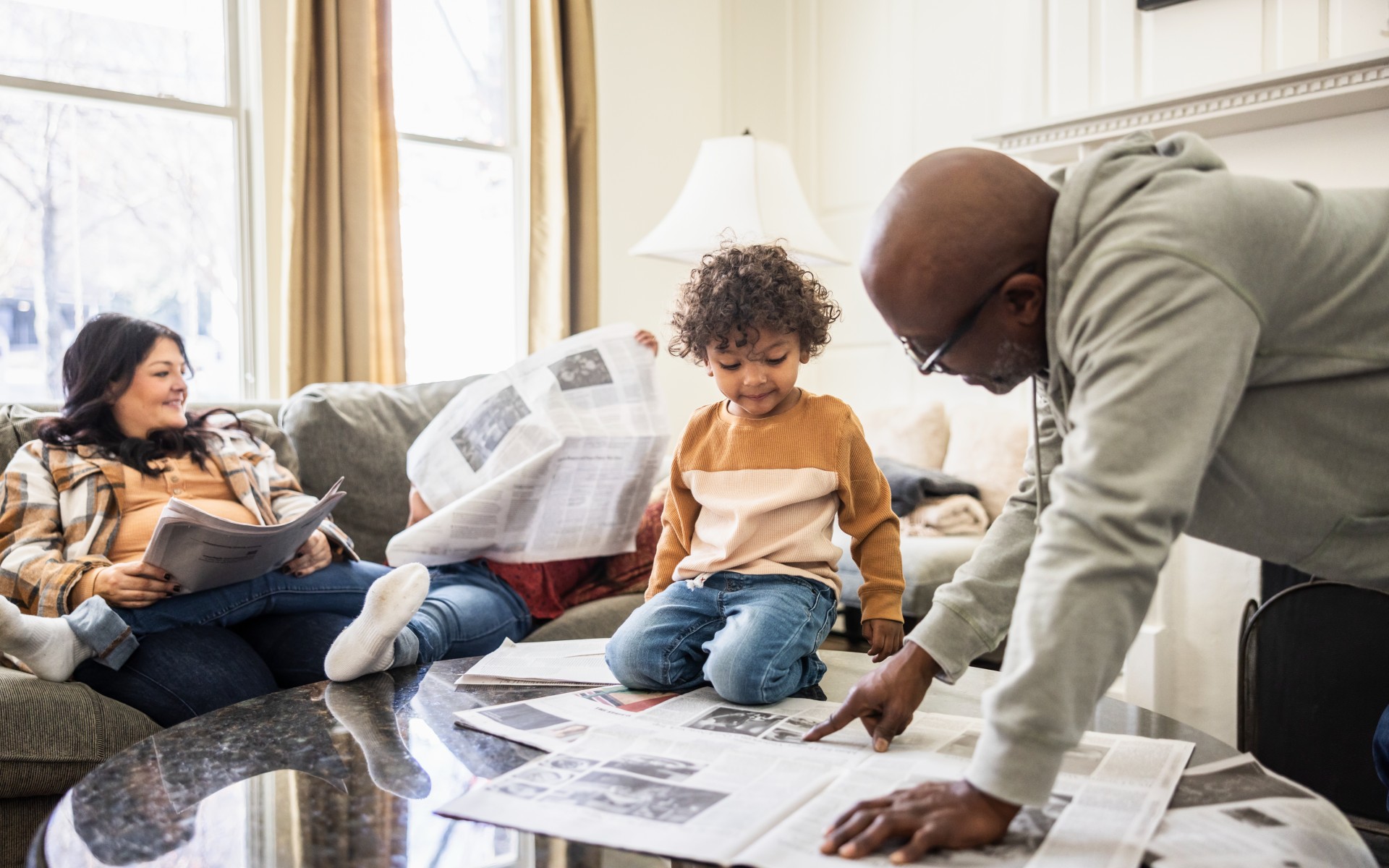Mother, father and small child reading the news together